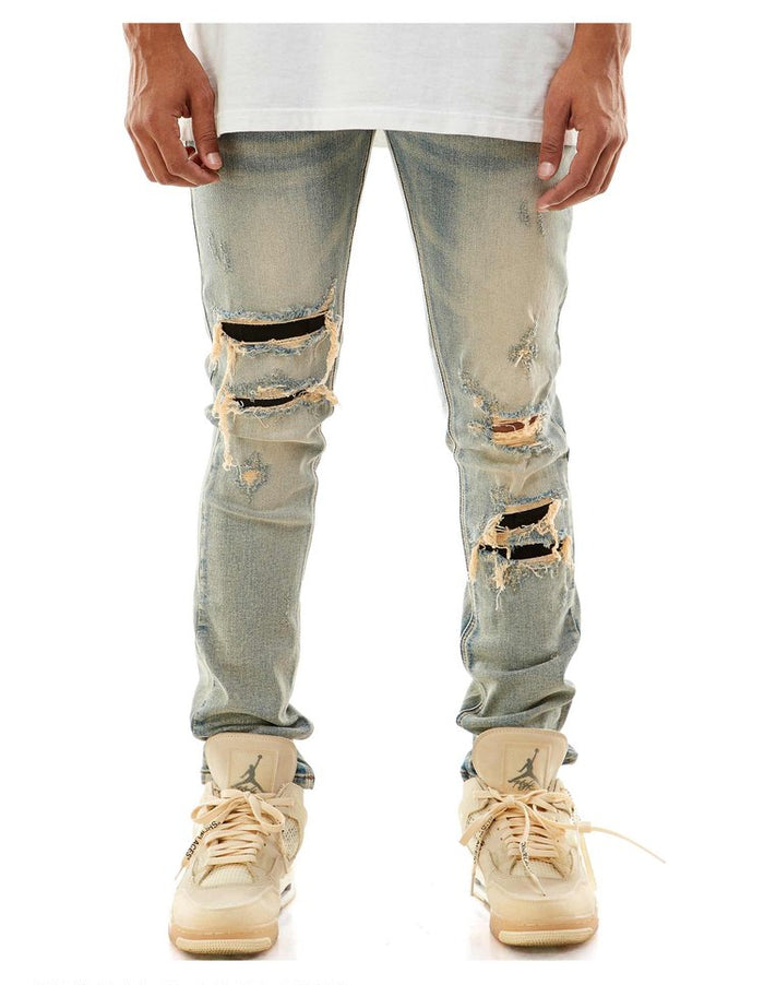 Blue KDNK Contrast Under Patched Denim jeans with distressed details, showcasing a stylish fit and unique patchwork design.