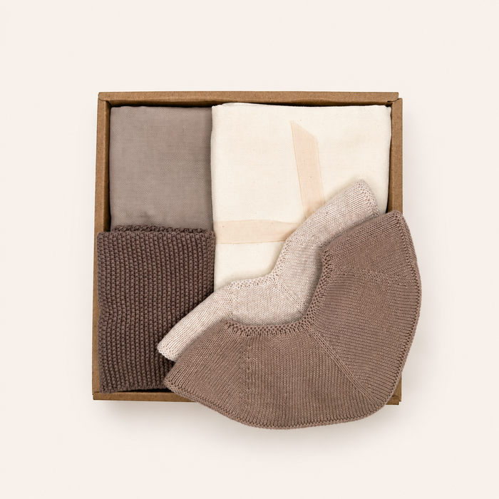 Luxury Baby Gift Box with two muslin cloths, two knitted baby bibs and a knitted washcloth in soft neutral Scandinavian colours by Saga Copenhagen.