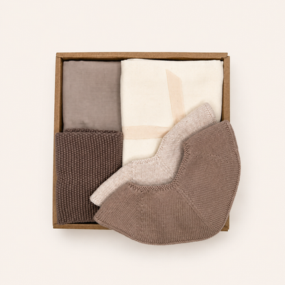 Luxury Baby Gift Box with two muslin cloths, two knitted baby bibs and a knitted washcloth in soft neutral Scandinavian colours by Saga Copenhagen.